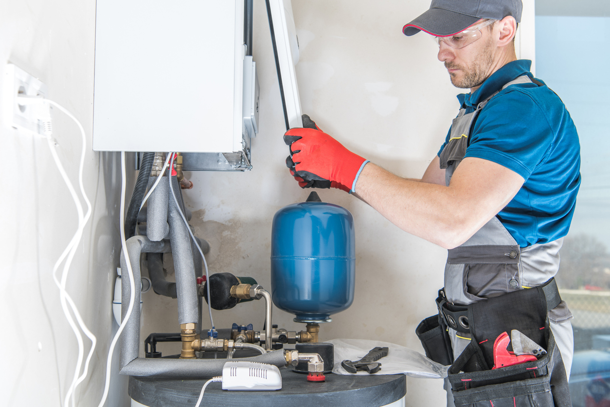 HVAC technician replacing the cover of a furnace after a maintenance service