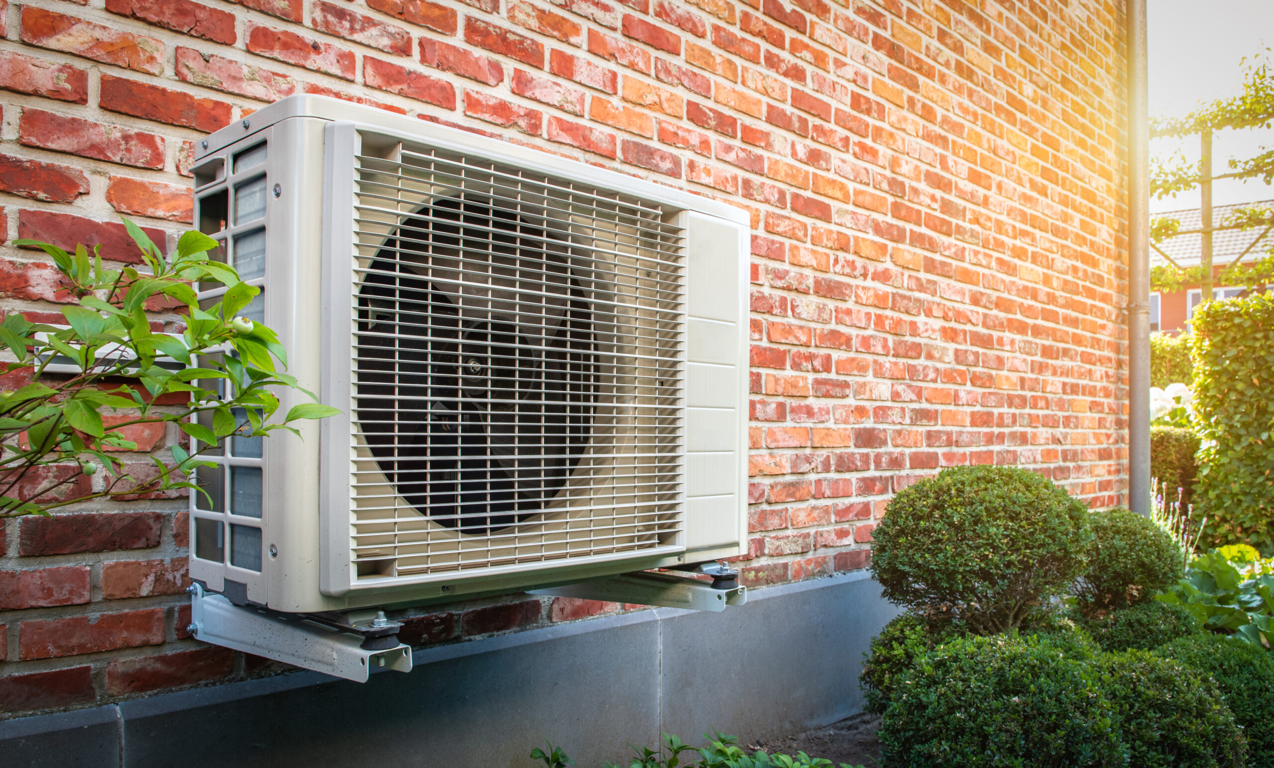 Heat pump unit mounted on brick wall