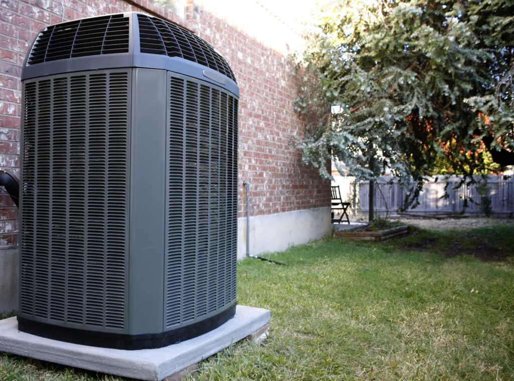 Newly installed AC unit outside a brick home